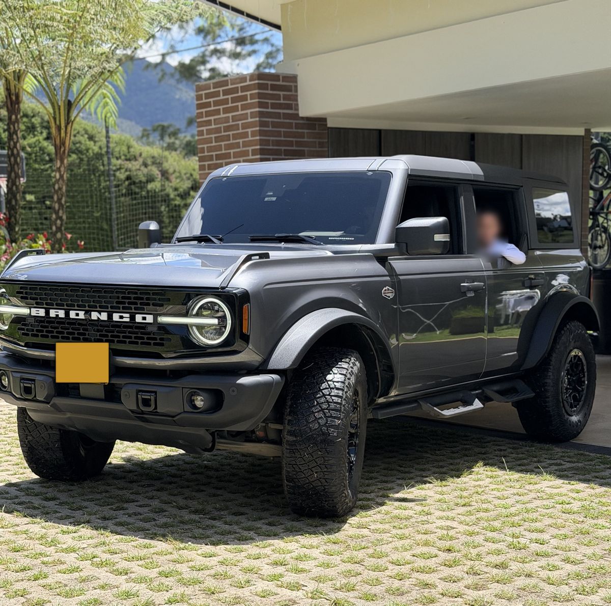 Ford Bronco gris recién detallado con un niño asomado por la ventana; su rostro está difuminado