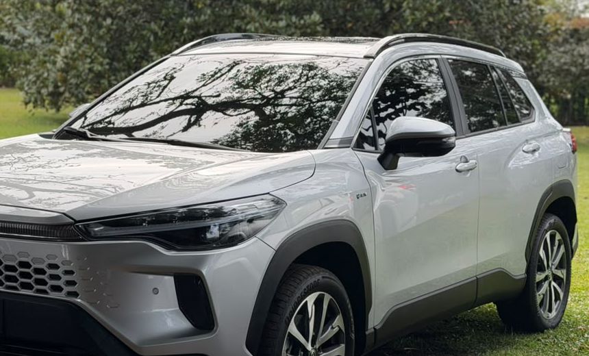 Toyota Corolla Cross plateado con el árbol reflejado en el capó